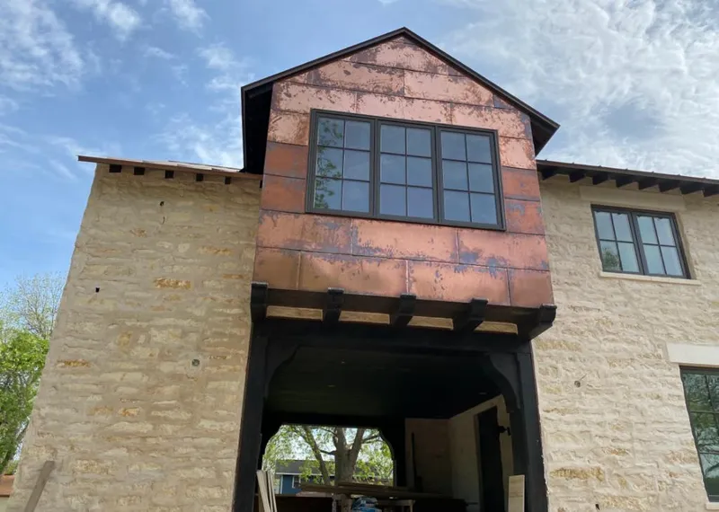Copper metal panel facade on a stone building for Metal Roof Coating in Cadillac